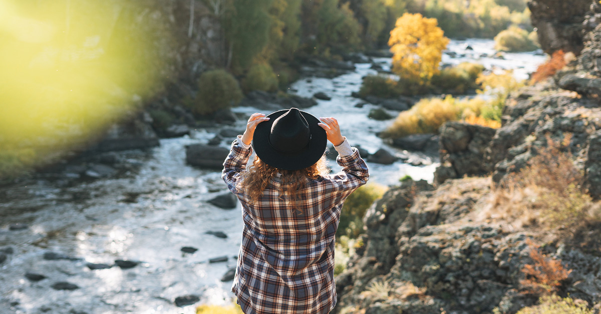 Woman standing at the edge of a river looking out — Amberly Neese blog on letting go and trusting God