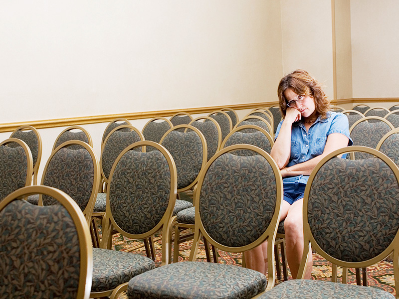 A bored woman resting her chin on her hand at an event